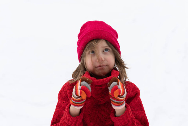 portrait of a little girl standing in a red sweater in winter - Photo, Image