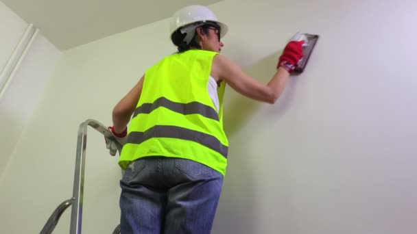 Vrouw bouwer behandelt de muur - Video