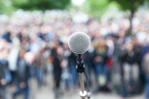 Microfone em foco contra protesto desfocado ou demonstração pública
 - Foto, Imagem