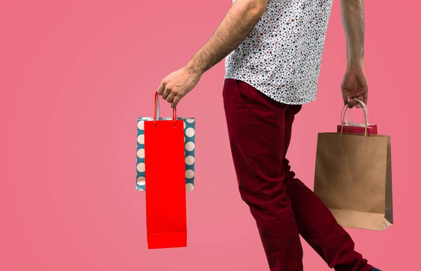 schöner Mann mit Brille mit Einkaufstasche auf rosa Hintergrund - Foto, Bild