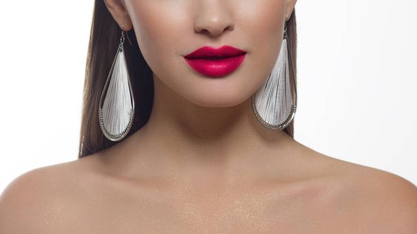 Close-up portrait of a beauty woman with straight hair and perfectly clean skin. Daytime makeup, styling and elegant decoration on the ears - earrings. Skin care in the spa salon or cosmetology - Valokuva, kuva