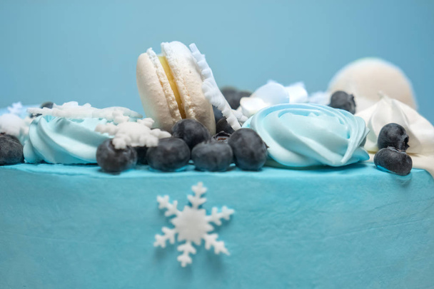 Białego śniegu na ciasto. Tort ozdobiony Zefir, zaphyr i jagody. Tortu zimą pokryte niebieski lany. Ciasto na tle na ferie zimowe. Ciasto stollen na nowy rok - Zdjęcie, obraz