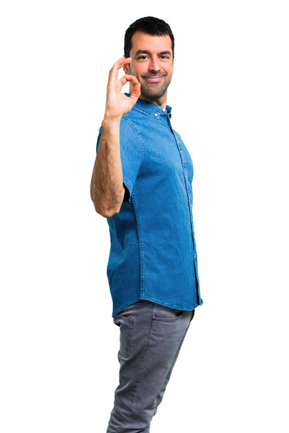 Pohledný muž s modrou košili ok známek s prsty - Fotografie, Obrázek