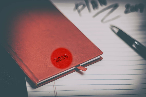 diaries, red skin, stationery. Diary for the year 2019. Ballpoint pen in black. outline word lettering. have toning. shallow depth of field. - Foto, Bild