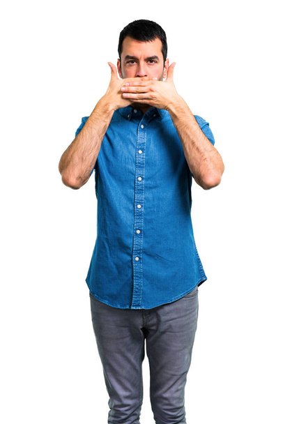 Handsome man with blue shirt covering mouth with hands - Фото, зображення