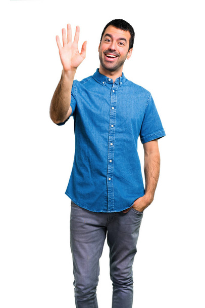 Handsome man with blue shirt saluting - Photo, Image