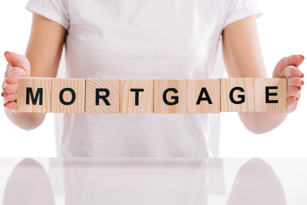partial view of woman holding wooden cubes with mortgage lettering isolated on white - Photo, Image