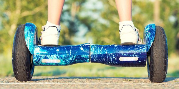 The boy is riding on a balance board.Legs on hover board. - Foto, Bild