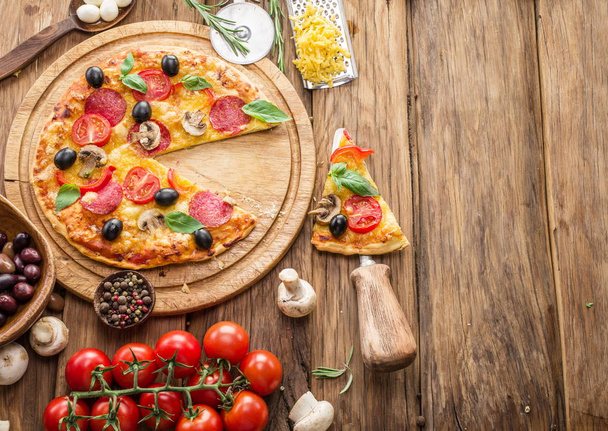 Pizza with mushrooms, salami and tomatoes. Top view. - Foto, Bild