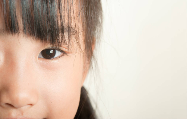 Asian little girl close up portrait.  Smiling children eye closeup focus. - Fotó, kép