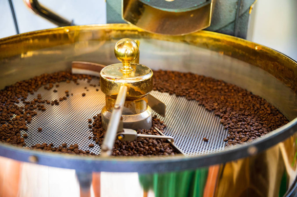 Granos de café orgánicos crudos tostados en máquina
 - Foto, imagen