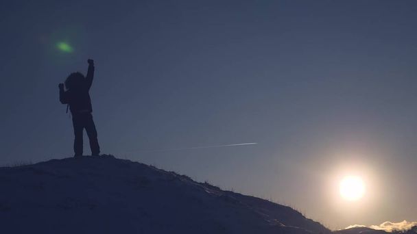 登山家は、雪の山を登る、スライド ダウンし、明るい太陽の光線で再び上昇します。彼の手とハッピー ジャンプを発生させます観光客喜ぶ彼の成功. - 写真・画像