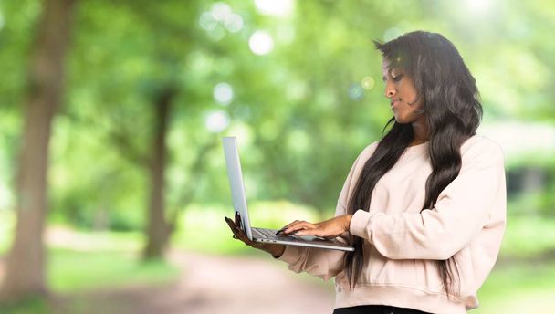 Joven mujer afroamericana con laptop al aire libre
 - Foto, imagen