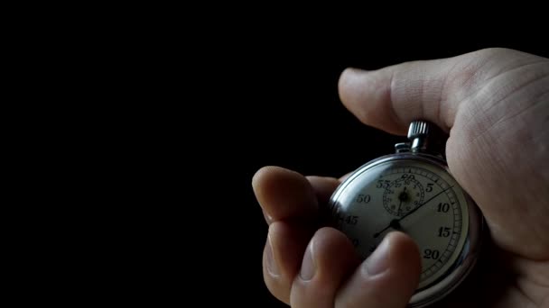 Χέρι που κρατά το χρονόμετρο σε μαύρο φόντο - Πλάνα, βίντεο