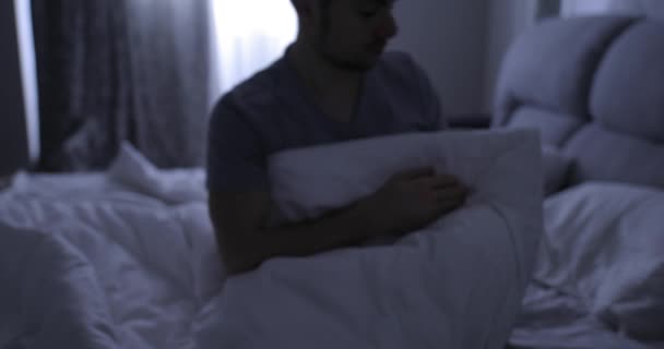 Depressed man in bed suffers from a symptom insomnia - Materiał filmowy, wideo