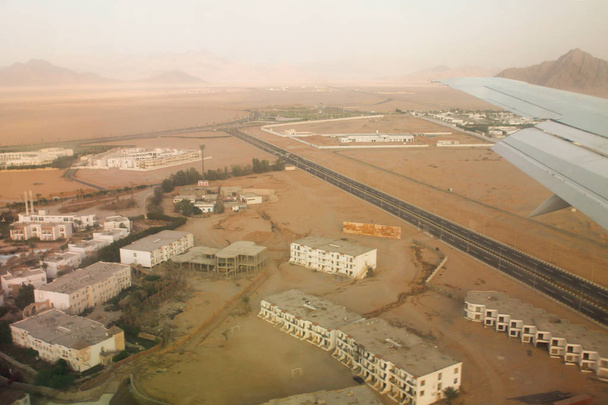 Uitzicht vanuit het raam van het vliegtuig. Vliegtuigen in de lucht. Vliegen over Sharm El Sheikh - Foto, afbeelding