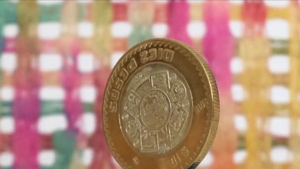 Moneda de 10 pesos mexicanos rotando sobre fondo colorido
 - Metraje, vídeo