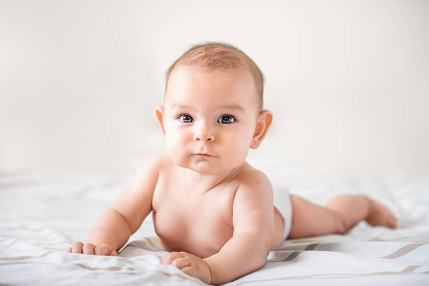 smiling happy newborn infant baby tummy time on bed bright airy copy space - Fotoğraf, Görsel