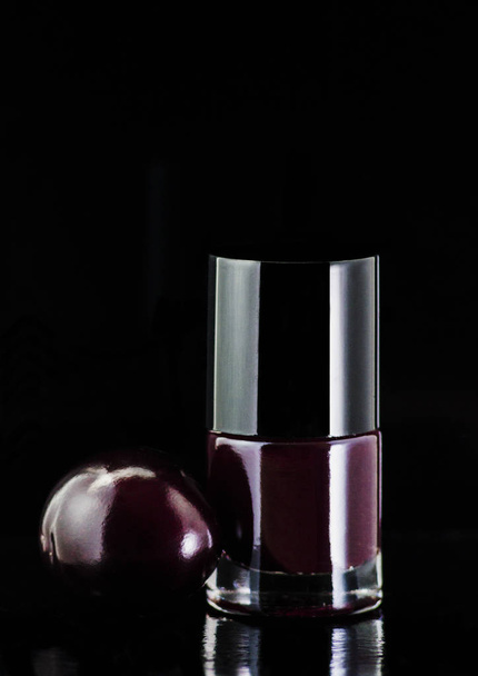 Vernis à ongles naturel couleur argent et prune sur fond noir
 - Photo, image