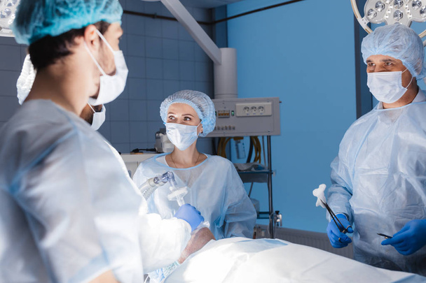 Anestezi ekibi hastayı ameliyathanede ameliyata hazırlıyor. - Fotoğraf, Görsel