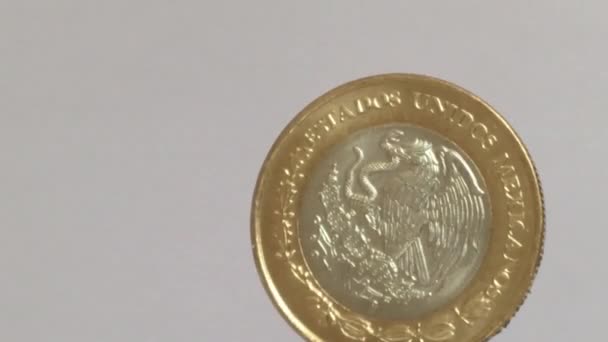 Moneda de 10 pesos mexicanos girando aislada sobre fondo blanco
 - Imágenes, Vídeo