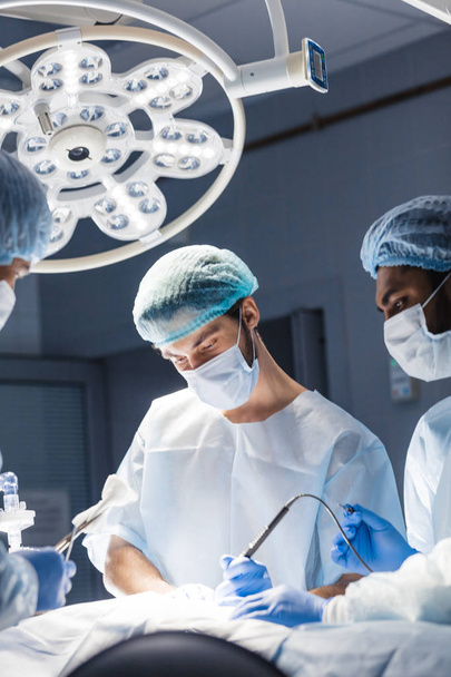 Young doctor, surgeon wearing medical protective mask in operating room - Photo, image