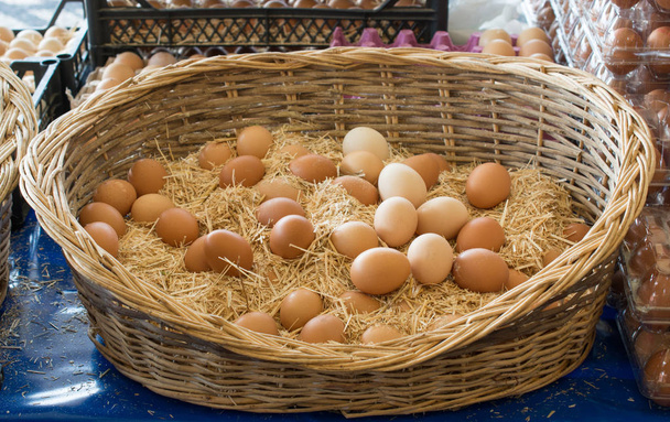 Органические свежие яйца в соломенной корзине - Фото, изображение