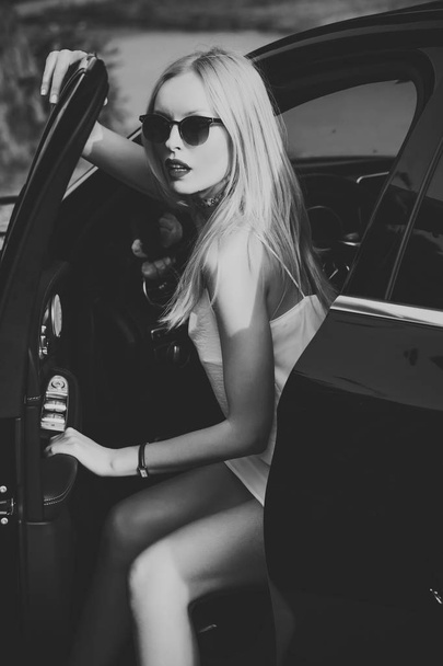 Businesswoman or pretty blonde girl with red lips in car. - Photo, Image