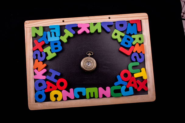 Cep saati ve tahtadan yapılmış alfabe harfleri. - Fotoğraf, Görsel