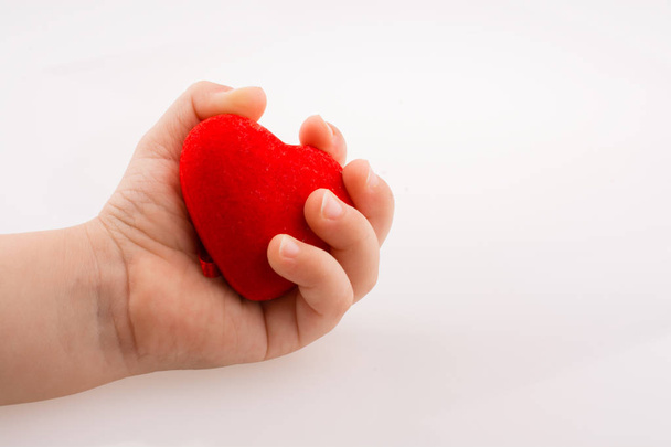 Petite forme de coeur de couleur rouge à la main sur fond blanc - Photo, image