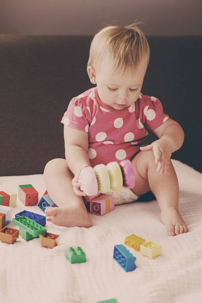 Cute baby girl playing with colorful plastic blocks indoors - Fotografie, Obrázek