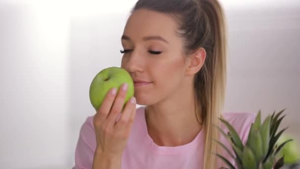 Healthy breakfast, happy woman sniff and eating green fresh apple on kitchen - Materiał filmowy, wideo