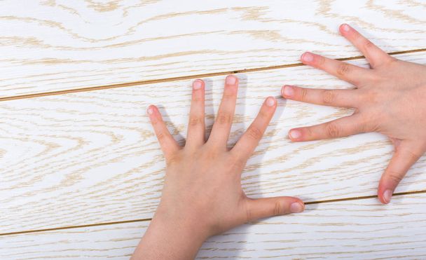 Handen maken van een gebaar op een houten achtergrond - Foto, afbeelding