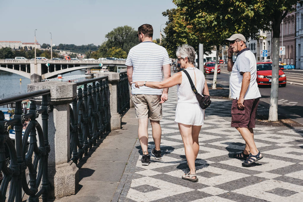 Prague, Czech Republic - August 23, 2018: People walking on the pedestrian walkway alongside Vltava river in Prague. Vltava is the longest river within the Czech Republic. - Foto, Imagen