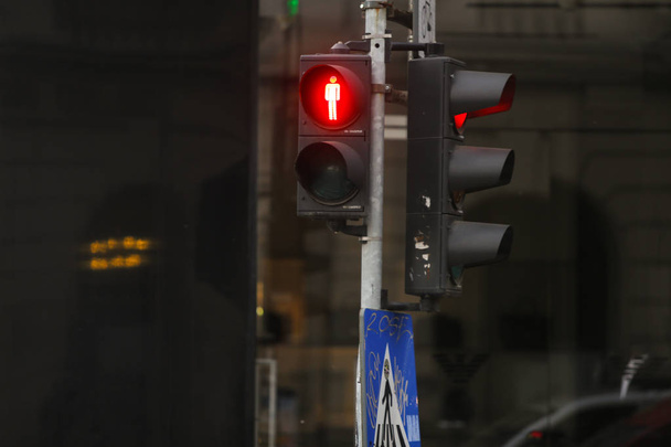 Красный светофор для пешеходов и красный для автомобилей на городской улице и знак пешеходного перехода
 - Фото, изображение