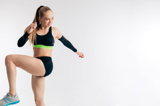 kobiety fitness młodych w sportowej podnoszenie jej kolana i robienie ćwiczeń - Zdjęcie, obraz