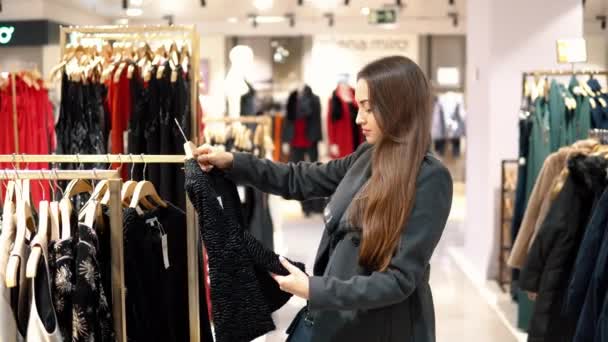 young beautiful woman finding herself new clothes in a store supermarket - Footage, Video