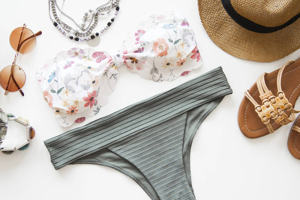 Vrouwelijke zomer bikini badpak accessoires op witte achtergrond - Foto, afbeelding