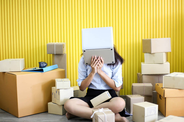 Tired unhappy of   Young asian girl is freelancer Start up small business owner writing address on cardboard box at workplace,Shipping shopping online small business entrepreneur SME or freelance - Valokuva, kuva