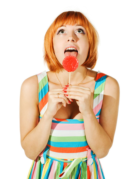Beautiful red girl with candy - Foto, afbeelding