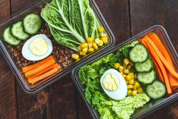 Healthy meal in a plastic container. Snack in the office, at work. Lunch box on a wooden background. Proper and healthy food concept. Diet  - Photo, image