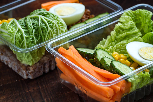 Healthy meal in a plastic container. Snack in the office, at work. Lunch box on a wooden background. Proper and healthy food concept. Diet  - Foto, Imagen