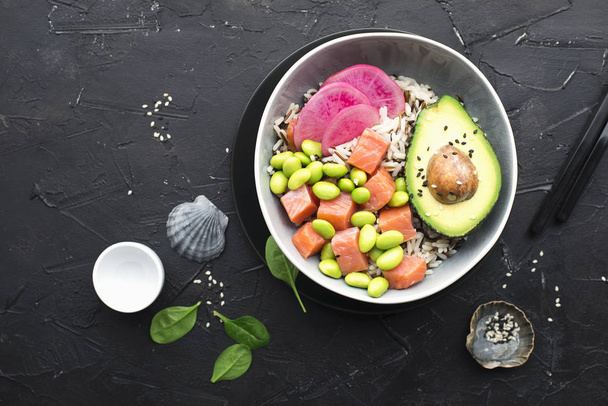 Fresh seafood recipe. Salmon and Caviar poke bowl with fresh prawn, brown rice, cucumber, pickled sweet onion, radish, soy beans edamame portioned with black and white sesame. Food concept poke bowl. - Foto, afbeelding