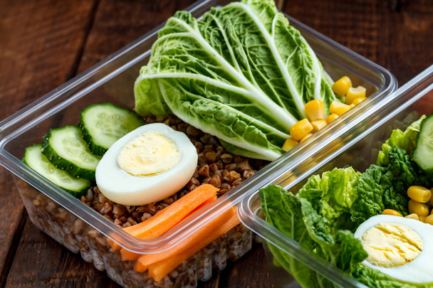 Healthy meal in a plastic container. Snack in the office, at work. Lunch box on a wooden background. Proper and healthy food concept. Diet  - Fotó, kép
