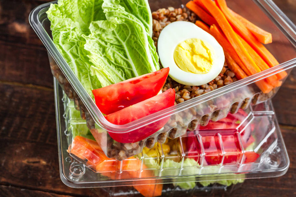 Dietary, healthy meal in a plastic container. Eat right concept. Snack at work, in the office at lunch time, during a break. Lunch box. Healthy food and nutrition concept  - Photo, image