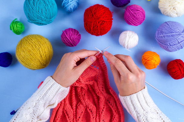 Knitting. Hobbies, crafts. Threads for knitting on a blue background. - Фото, изображение