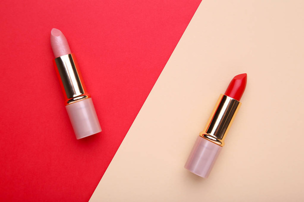 Two colorful lipsticks on colorful background. Cosmetic - Zdjęcie, obraz