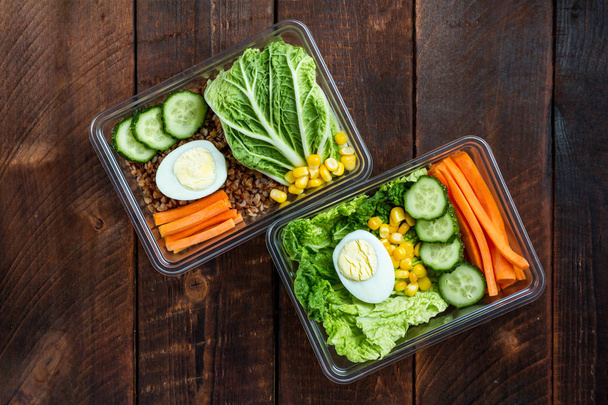 Healthy meal in a plastic container. Snack in the office, at work. Lunch box on a wooden background. Proper and healthy food concept. Diet  - Photo, Image