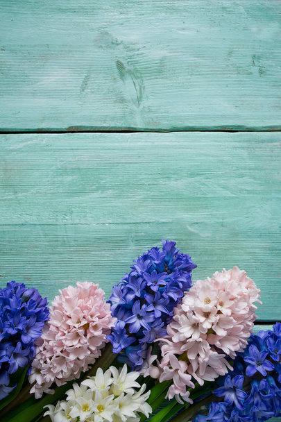 beautiful hyacinth flowers on turquoise wooden surface - Foto, afbeelding