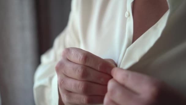 A man dresses in a shirt - Filmati, video